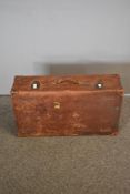 An early 20th century leather bound suitcase in mid brown textured leather with stitched corners.