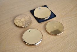 Four 1940-1960s Stratton Made in England compacts, in engine turned gilt metal; two of the 'Stratton