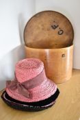 A vintage wooden hat box with the initials 'C.F.' hand painted on the lid, containing five ladies