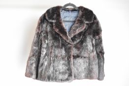 A vintage fur jacket in black-brown fur with a subtle midnight blue shift and shimmer to it, lined