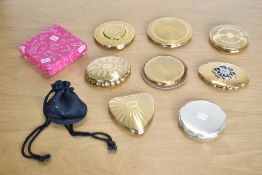 Eight vintage Kigu of London engine turned gilt metal compacts, including a 'Limelight' music-box