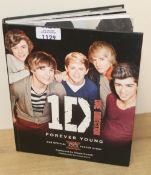 A One Direction Book that comes ( unverified ) signed by all the members - this is the Forever Young