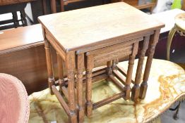 A reproduction oak nest of three tables