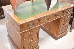 A Victorian oak pedestal desk having inset leather top and brass aesthetic style handles, locks