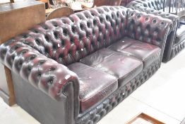 Two Chesterfield settees, in burgundy leather, three and two seater