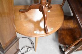 A vintage Ercol or similar drop leaf occasional coffee table on three legs with drop flap, width