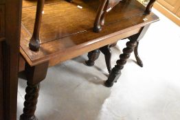 An early 20th Century oak hall table having heavy twist leg, and two footstools