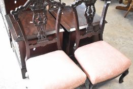 A pair of Victorian low seat nursing chairs having foliate backs and overstuffed seats