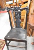 A period oak dining chair having solid seat and figural decoration to back