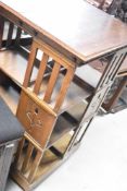 An Art Nouveau oak revolving bookcase having typical stylised tulip decoration, approx. 63 x 63cm,