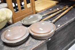 Three traditional copper and brass bed warming pans