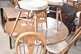 A vintage Ercol drop leaf table and set of four swan back dining chairs