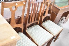 A pair of Arts & Crafts oak dining chairs, and a third similar with matching upholstery