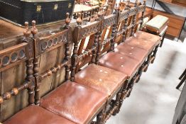 A set of seven Victorian semi gothic oak dining chairs having turned rails and additional carved and