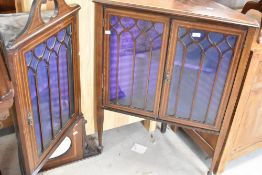 An Edwardian full height corner corner display having gothic style glazing and central mirror