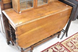An early to mid 20th Century oak gateleg dining table having shaped top and twist leg, width approx.