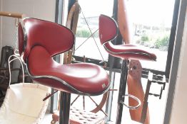 A pair of modern bar stools in the vintage style, chrome and red vinyl