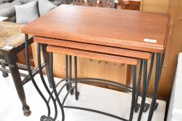 A modern nest of tables having wrought iron frames