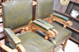 A pair of late 19th or early 20th Century golden oak framed armchairs having green leather