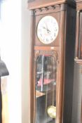 An early 20th Century oak cased long cased clock having silvered dial with Arabic numerals, and