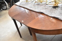A George III mahogany dining table comprising D ends and central leaf
