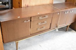A vintage (mid century modern) walnut sideboard having cupboard and drawer sections, including