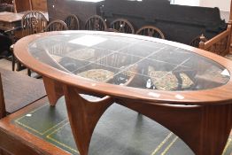 A vintage teak Astro style glass topped coffee table of oval form, approx. 122 x 66cm