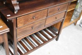 A modern mahogany sideboard having four drawers and slatted undertier, width approx. 104cm