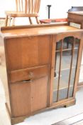 An early to mid 20th Century oak and ply bureau or cocktail cabinet having shelved display section ,