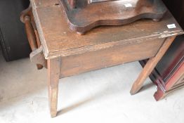 A vintage oak washstand or stool having lift lid and rails to end, width approx. 65cm