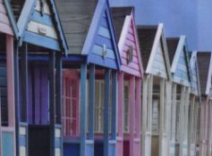 A decorative colour photographic print, colourful beach huts, within a white card mount and white