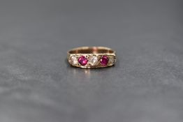 A 9ct gold ruby and white gemstone set ring, the two round cut rubies interspered with three clear