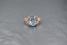 An Egyptian gold synthetic blue spinel set solitaire ring, the oval cut spinel in a four claw