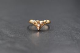 A 14ct gold diamond set wishbone ring, the wishbone having three diamonds to one said and a single