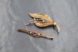 A 15ct gold amethyst and pearl set bar brooch, the central round cut bezel set amethyst flanked by