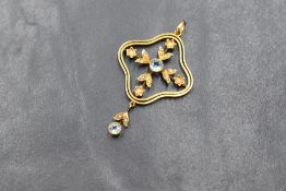 An Edwardian 9ct gold aquamarine and seed pearl set pendant, the central bezel set aquamarine in a