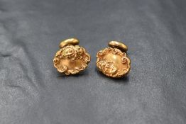 A pair of yellow metal Art Nouveau cufflinks stamped 14K having embossed oval front panels depicting