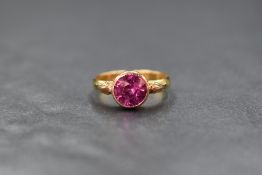 A 22ct gold pink sapphire set solitaire ring, the later addition rose gold bezel set round cut