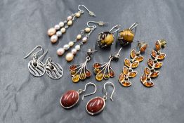 Six pairs of silver and white metal earrings including Baltic amber, Tigers eye, seed pearl,