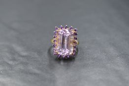 A 9ct gold amethyst ring by QVC having a large baguette cut amethyst within a border of small