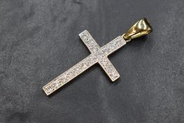 A large 9ct gold and cubic zirconia set cross pendant having 17 pave set cubic zirconia in a plain