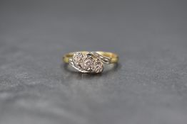 An 18ct gold diamond trilogy ring, having three small diamonds in illusionary mounts to cross over