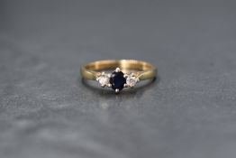 A 9ct gold sapphire and diamond trilogy ring having a central oval sapphire, approx 0.25ct,
