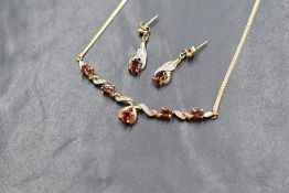 A 9ct gold necklace with matching earrings having a fire opal style stone and diamond chip set