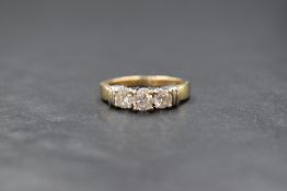 A 14ct gold diamond set trilogy ring, the three brilliant round cut diamonds in four claw