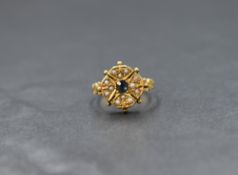 A Victorian 15ct gold sapphire and seed pearl ring, the central old cut sapphire surrounded by