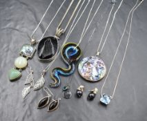 Seven pendants on silver chains, all of different forms including glass snake, slate, abalone shell,