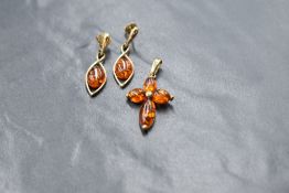 A 9ct gold Baltic amber pendant and earrings, the pendant in the form of a cross and the earrings