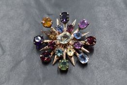 A yellow metal presumed gold gemstone set sunburst brooch, the round and oval cut gemstones