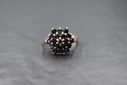 A 9ct gold sapphire triple cluster ring having a raised claw set mount on a 9ct gold loop, size